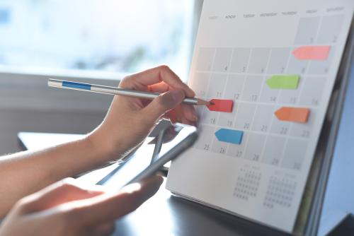 Person marking dates on a calendar 